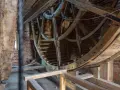 Drewniana konstrukcja wewnątrz gdańskiego Żurawia, z widocznymi ceglanymi ścianami i elementami mechanizmu.