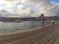 Drewniany deptak nad wodą, widok na marinę i zabudowania Sopotu. Idealne miejsce na spacer i odkrywanie, co to do zrobienia w Sopocie.