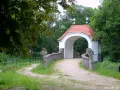 Kamienna furtka z aniołami prowadzi do Kalwarii Wielewskiej. Kręta ścieżka wśród zieleni zaprasza do kontemplacji.