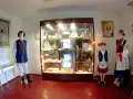W muzeum kaszubskim prezentowane są tradycyjne stroje i rękodzieło. Manekiny w ludowych strojach stoją obok gablot z eksponatami.
