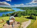 Malowniczy krajobraz Kaszub z wiatrakiem, jeziorem i lasami.