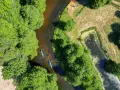 Dwie kajaki płyną rzeką pośród zieleni. To wspaniałe **Kociewie atrakcje** dla miłośników przyrody i aktywnego wypoczynku.