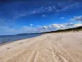Piękna, piaszczysta mechelinki plaża z widokiem na morze i las.