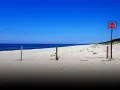 Plaża na mierzei wiślanej. Siatka i znak STOP wyznaczają granicę.