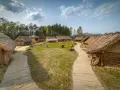 Sławutowo atrakcje: drewniane chaty kryte strzechą, kamienie i ścieżki tworzą klimat dawnej osady.