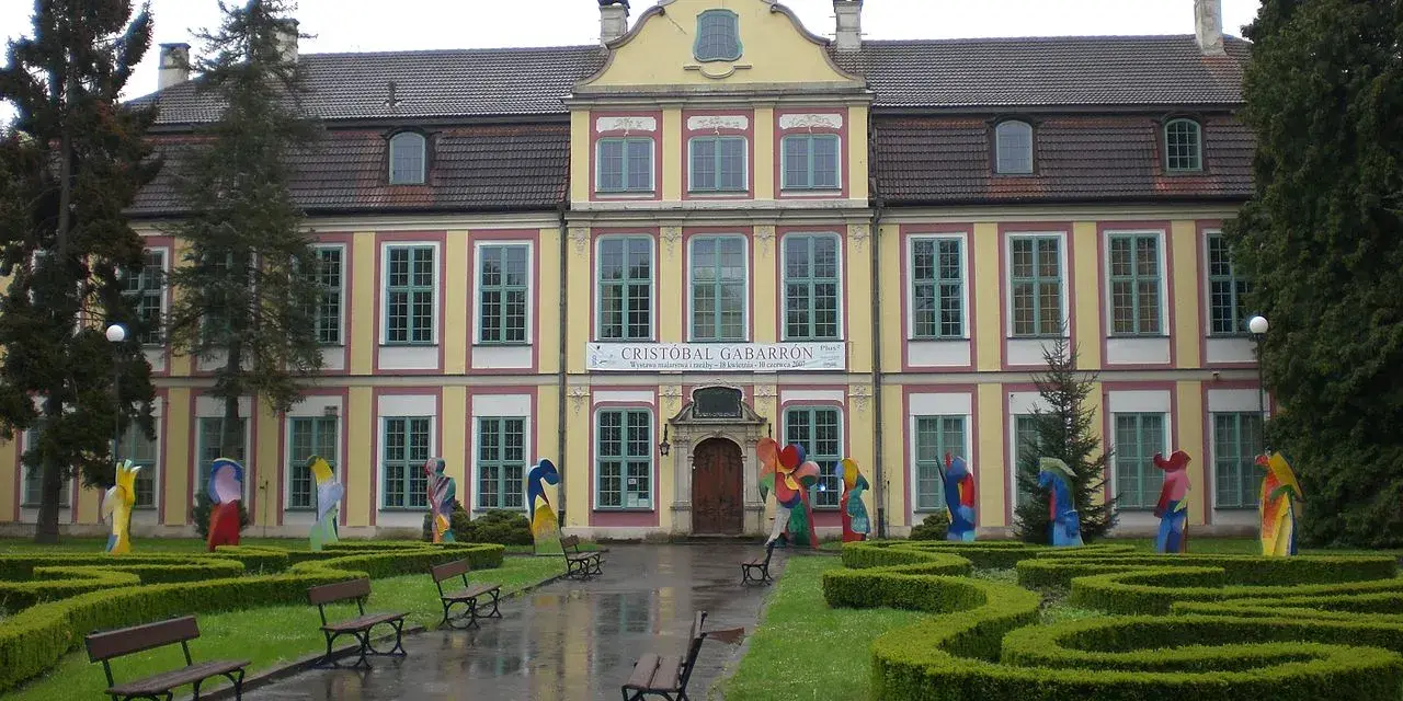 Pałac Opatów zaprasza na wystawę Cristobala Gabarrona. Kolorowe rzeźby zdobią dziedziniec przed zabytkowym budynkiem.