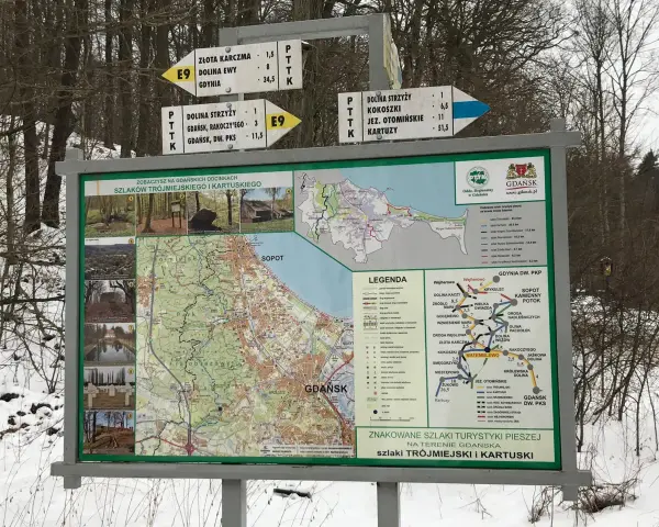 Mapa szlaków turystycznych w Gdańsku, Matemblewo. Znaki drogowe wskazują kierunki i odległości do różnych miejsc.