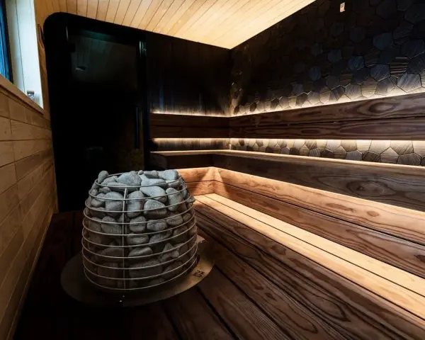 Władysławowo atrakcje na niepogodę: nowoczesna sauna z kamiennym piecem i nastrojowym oświetleniem. Idealne miejsce na relaks.
