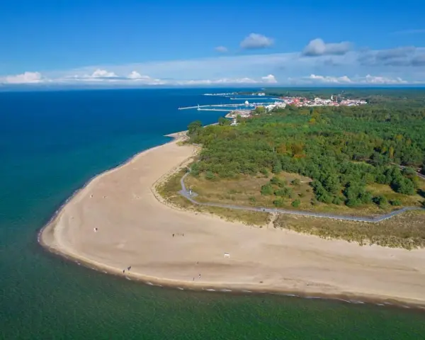 Plaża i las sosnowy nad morzem, w oddali widać miasteczko z portem. Góra Szwedów to idealne miejsce na spacer.