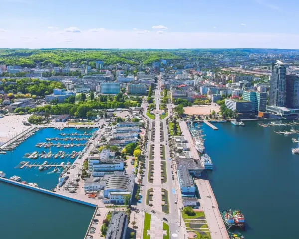 Widok na Gdynię z lotu ptaka: port jachtowy, plaża, nowoczesne budynki i zieleń. Ciekawe ciekawostki o Gdyni czekają na odkrycie!