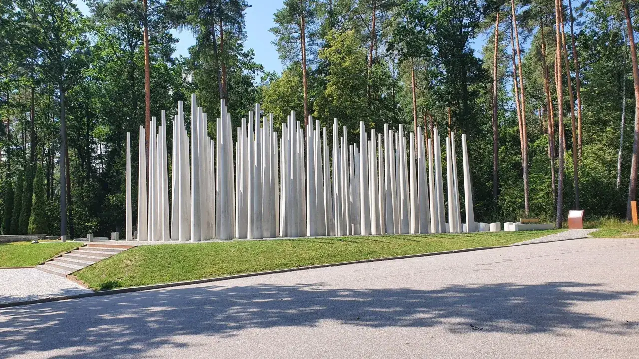 Pomnik w lesie, przypominający las białych, stożkowych kolumn. Miejsce pamięci w Starogardzie Gdańskim.