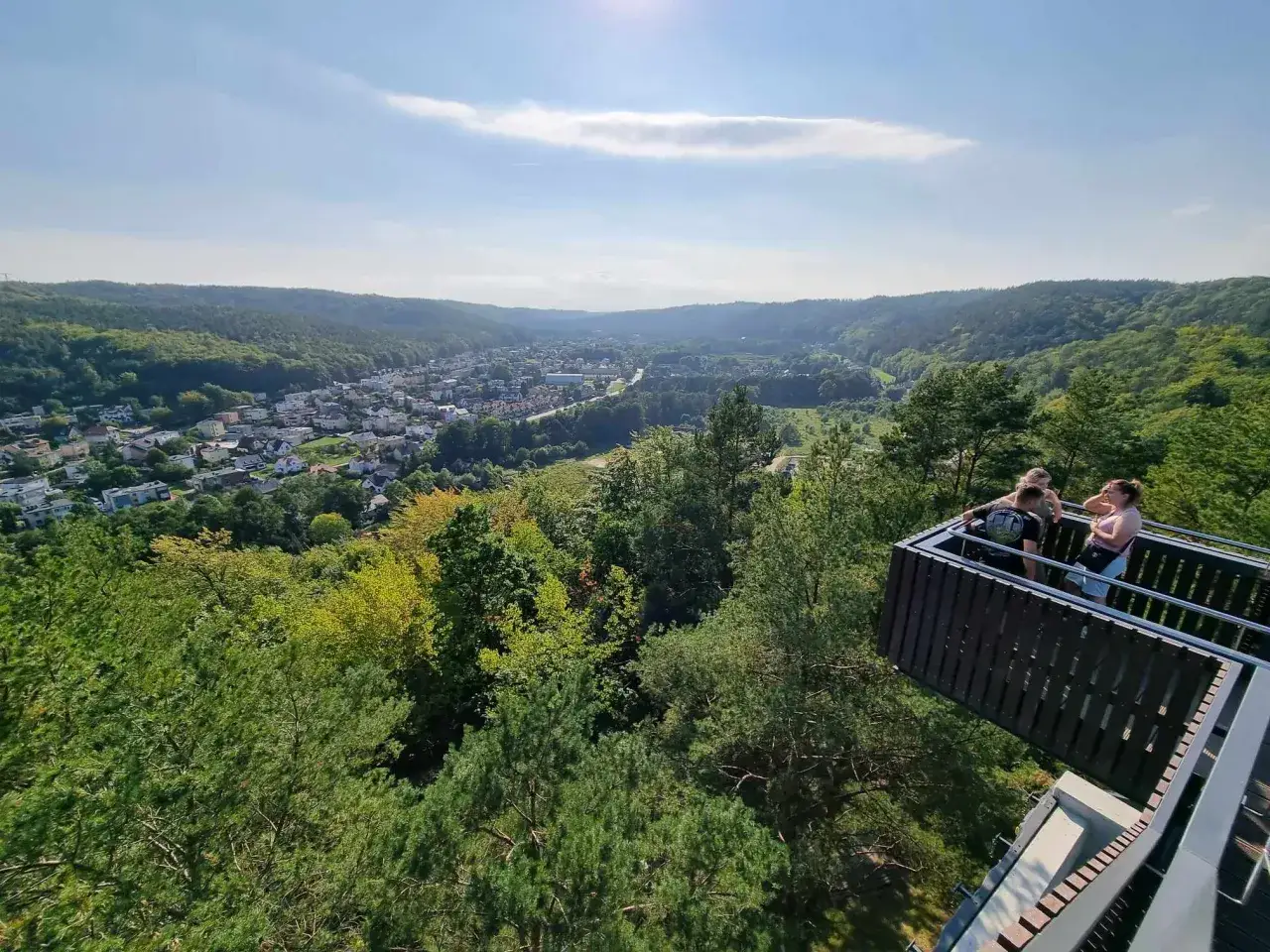 Widok z punktu widokowego w Rumi na dolinę i miasto. Trzy osoby podziwiają panoramę.