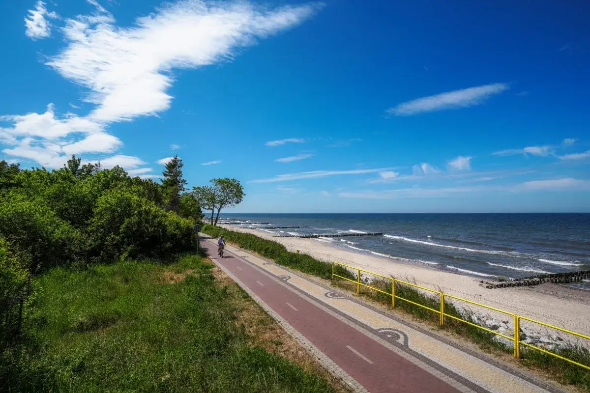 Ścieżka rowerowa wzdłuż plaży nad Morzem Bałtyckim. Malownicze miejscowości nad Bałtykiem zachęcają do aktywnego wypoczynku.